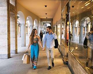 Ein glückliches Paar spaziert in einem Einkaufsbereich.