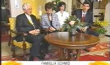 Quattro persone sedute attorno a un tavolo con fiori.