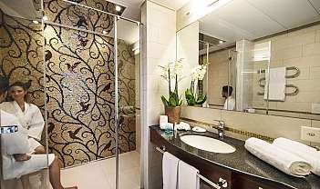 Interno di un bagno moderno con mosaico e piante decorative.