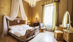 Interno di una camera d'albergo con letto e arredamento raffinato.