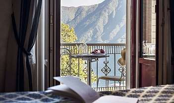 Balcon avec table, chaises et fruits avec vue sur le lac et les montagnes