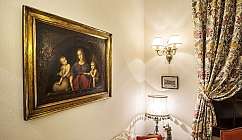 Una stanza con un dipinto della Madonna e lampada da tavolo.