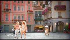 Due persone passeggiano in una piazza di Lugano.