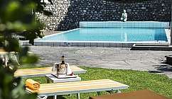 Lettini a strisce gialle vicino a una piscina blu.