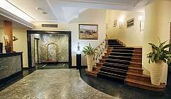 Hall di un hotel con reception e scala elegante.