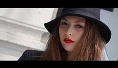 Ritratto di una giovane donna con labbra rosse e cappello.