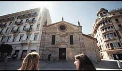 Due persone sorridono davanti a una chiesa storica.