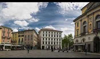 Vista panoramica di una piazza con caffè e architettura storica.