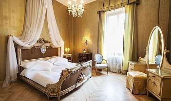 Camera da letto elegante con letto a baldacchino, poltrona e specchiera antica