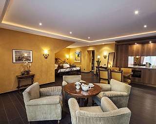 Chambre d'hôtel avec coin salon et cuisine.