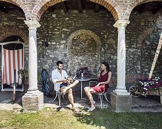Deux personnes assises dans une cour avec des colonnes et des plantes.