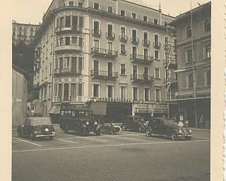 Black and white image of a building with vintage cars.