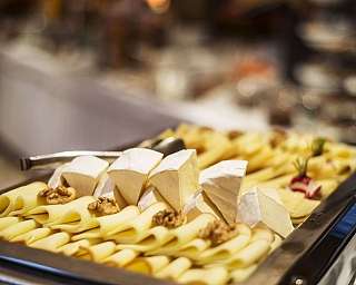 Tablett mit Käse und Pasta, dekoriert mit Nüssen.