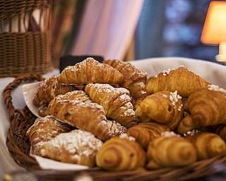 Korb mit frisch gebackenen Croissants mit Puderzucker.