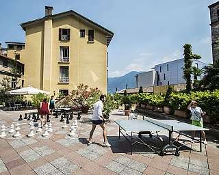 Des personnes jouant aux échecs et au ping-pong dans une zone extérieure.
