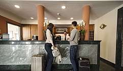 Couple s'enregistrant à la réception de l'hôtel avec des bagages.