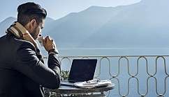 Uomo al computer con caffè