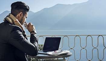 Uomo al computer con caffè