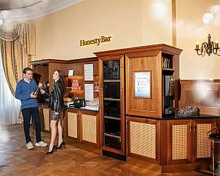 Deux personnes interagissent au bar Honesty avec des boissons.