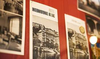Affiche vintage de l'hôtel International Au Lac accrochée à un mur rouge