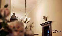 Entrée d'une taverne avec un lustre ancien et une décoration murale en forme d'ange