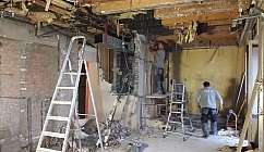 Deux ouvriers au travail dans un environnement en cours de démolition.