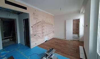 Chambre avec mur décoré et sol en bois.