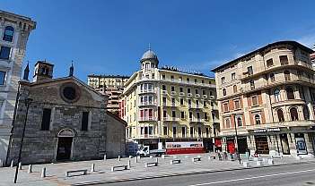 Vue d'une place avec une église et des hôtels historiques.