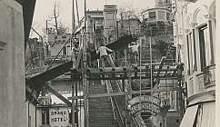 Travailleurs sur une structure en bois dans une rue historique.