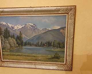 Dipinto di un paesaggio montano con un lago e alberi.