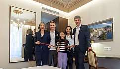 A group of people cutting a ribbon in an elegant room.