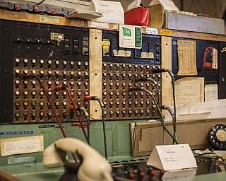 Un ancien central téléphonique avec des câbles et des boutons.