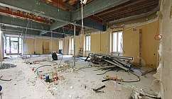 Empty space with construction materials and pipes in a building site.