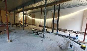 Workspace under renovation with pipes and supports.
