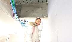 A smiling girl in a corridor with coloured pipes.