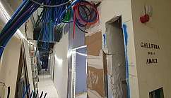 Corridor with coloured pipes and walls under construction.