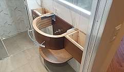 Wooden bathroom cabinet with sink and storage space.