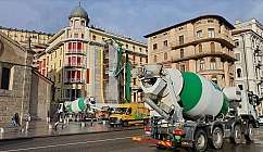 Cement truck on a street with historic buildings.