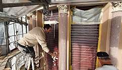 Deux ouvriers au travail sur une façade en rénovation.