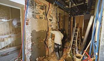 Un travailleur répare un mur sur un chantier.