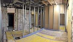 Espace en rénovation avec des murs en métal et un sol en bois.