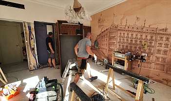 Deux ouvriers au travail dans un environnement en rénovation.