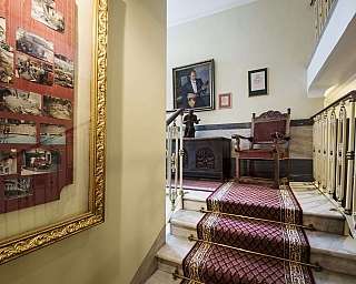 Scala con fotografie storiche e arredi classici.