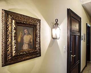 Corridoio con un dipinto incorniciato e una lampada a parete.