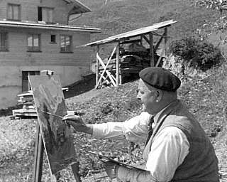 Un uomo sta dipingendo su un cavalletto in un paesaggio naturale.