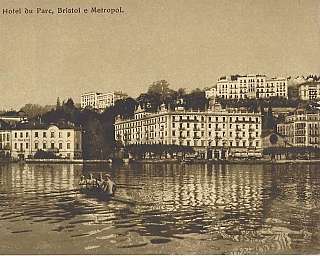 Panorama of Lugano with hotel and rowing boat on the lake.