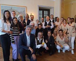 Un gruppo di persone in un ambiente elegante, sorridendo e posando insieme.